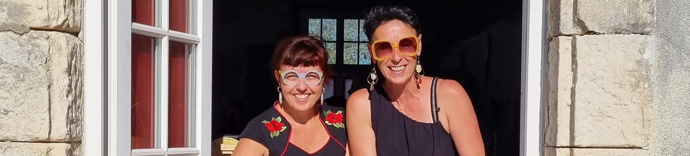 deux personnes souriantes devant un panneau buvette